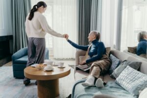 elderly lady holding the hand of a caregiver